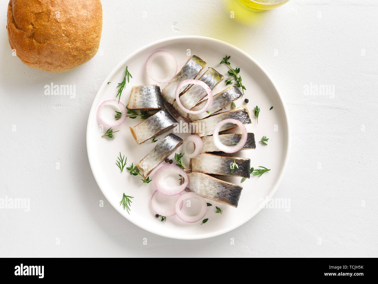 Solrig spørgeskema Sommerhus Marinated herring slices with spice, herbs and onion on plate on white  stone background. Food with healthy unsaturated fats, Omega 3. Top view,  flat l Stock Photo - Alamy