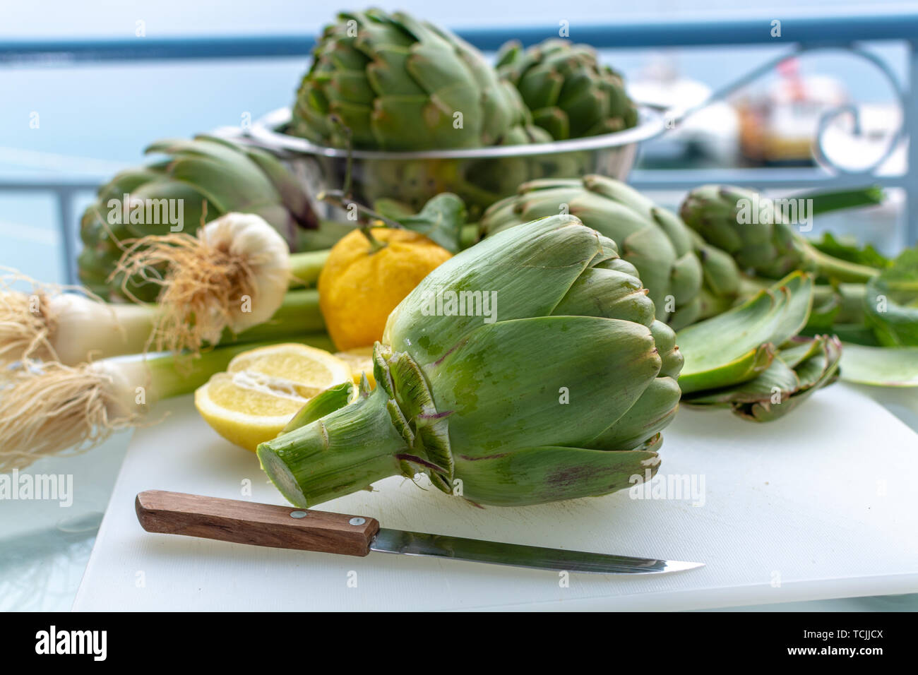 Preparation of heads of fresh raw green artichokes plants from
