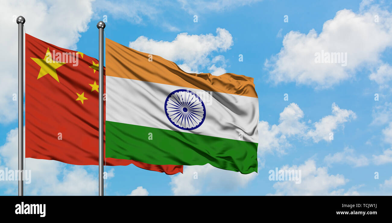 China and India flag waving in the wind against white cloudy blue sky together. Diplomacy concept, international relations. Stock Photo