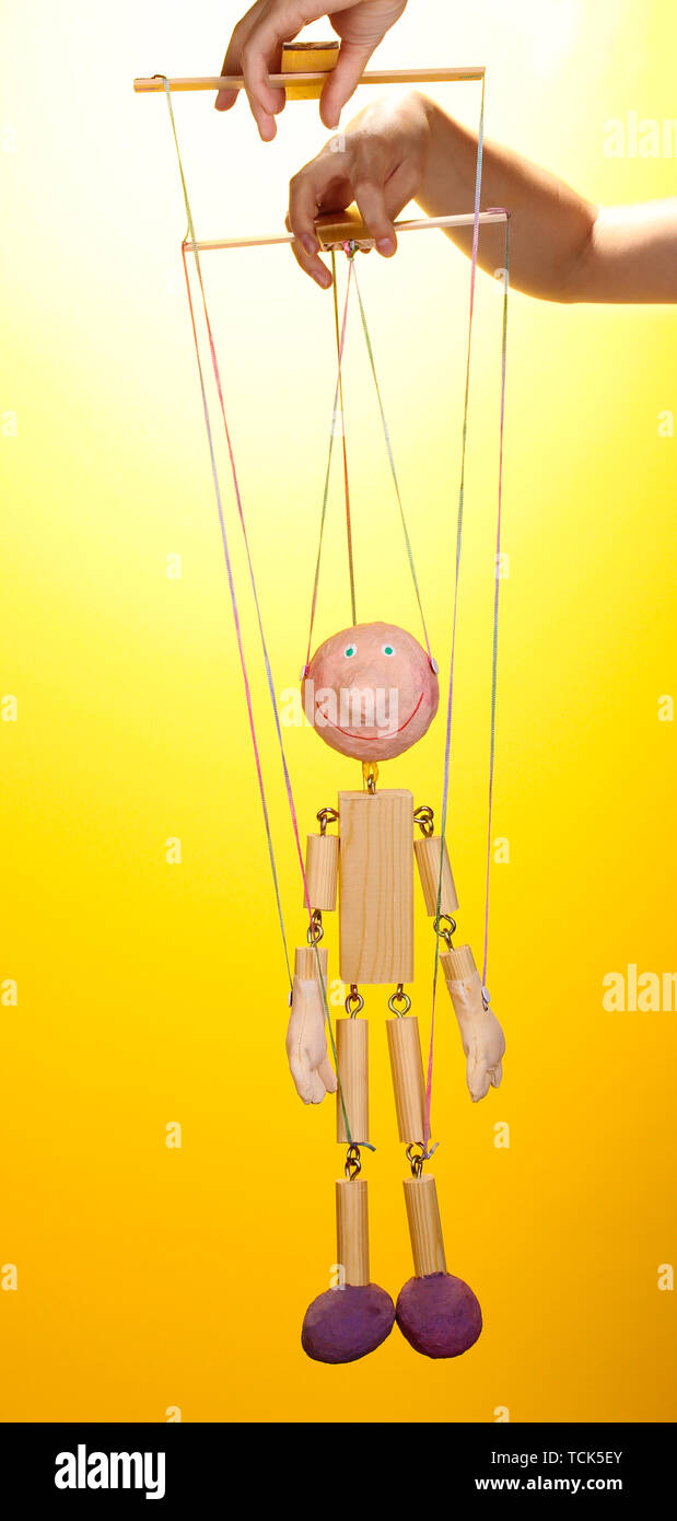 Wooden puppet on yellow background Stock Photo - Alamy