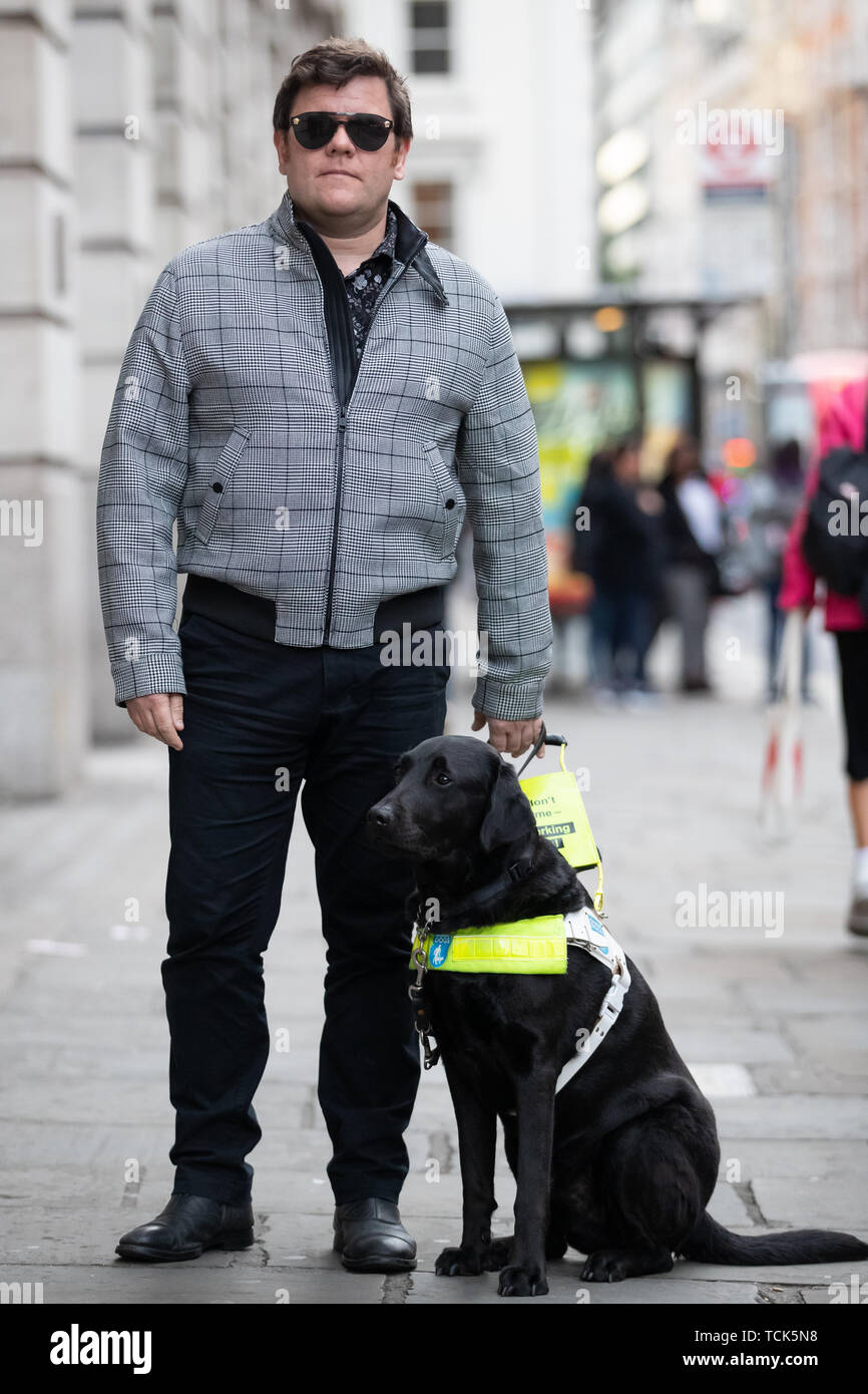 British Paralympic skiing champion John Dickinson-Lilley, with his guide dog Brett, outside the Sainsbury's Local store on Southampton Row in Holborn, central London, minutes from the supermarket chain's head office, where he was twice refused entry along with his dog. Stock Photo