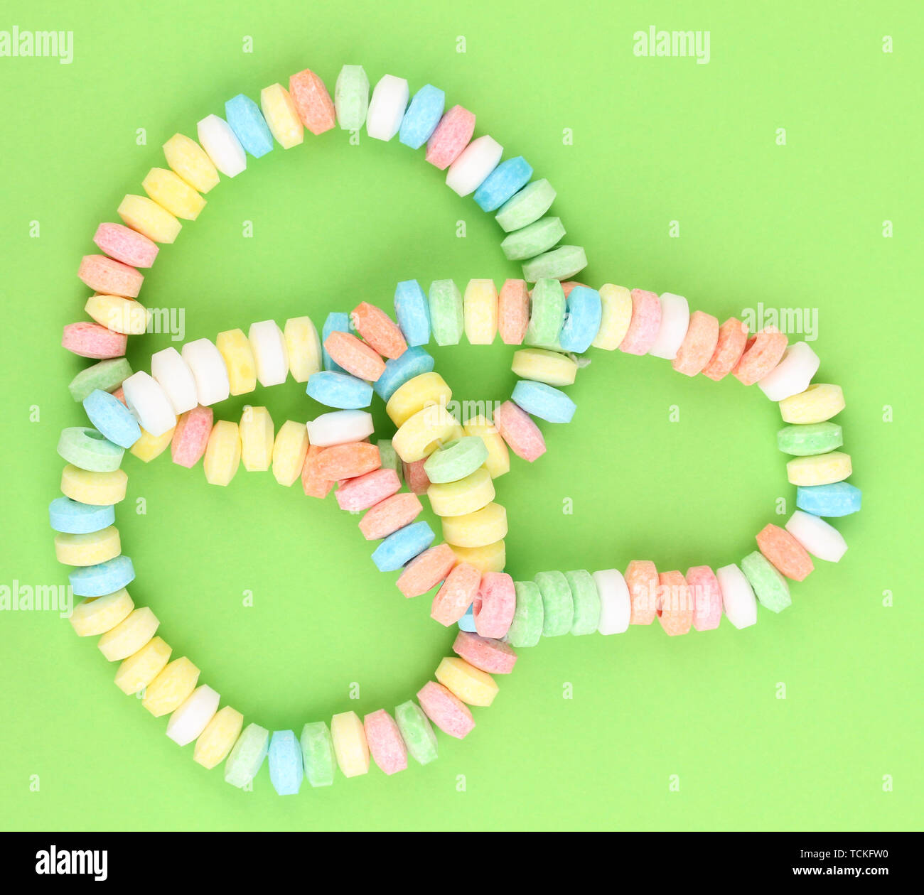 Color candies on rope on green background Stock Photo - Alamy