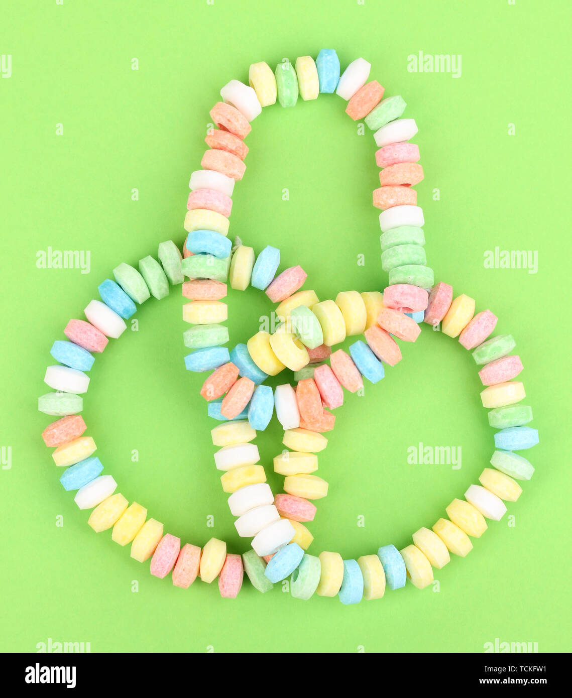 Color candies on rope on green background Stock Photo - Alamy