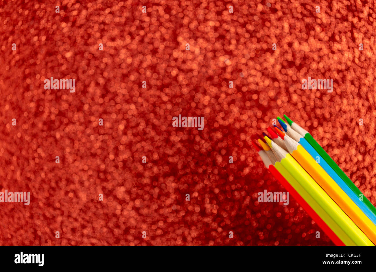 Colored pencils on glitter red background Stock Photo