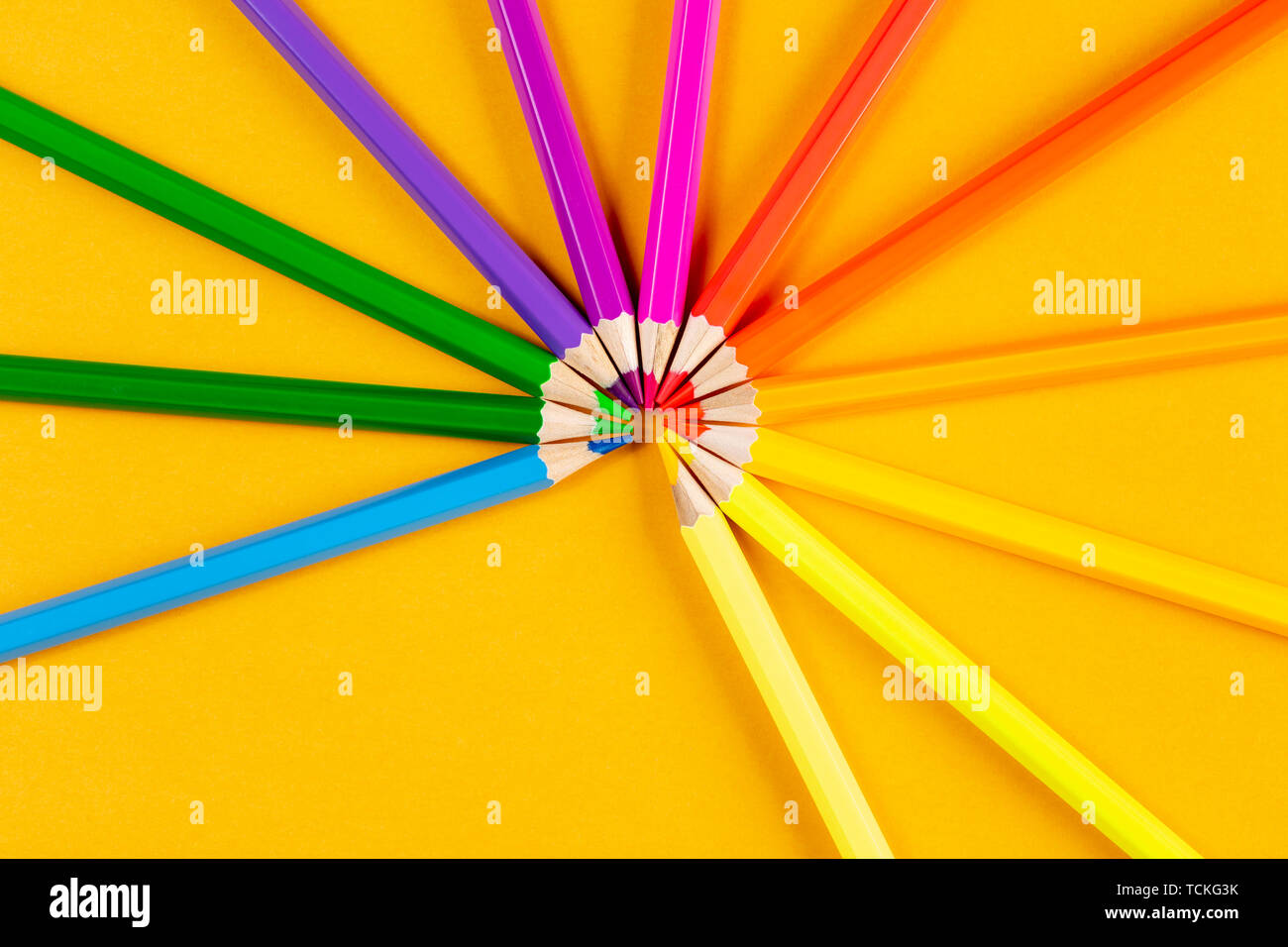 Colored pencils on yellow background Stock Photo - Alamy