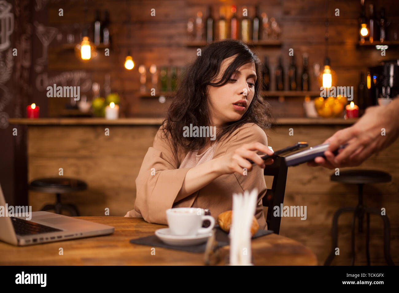 photo of beautiful young woman paying with credit card at a