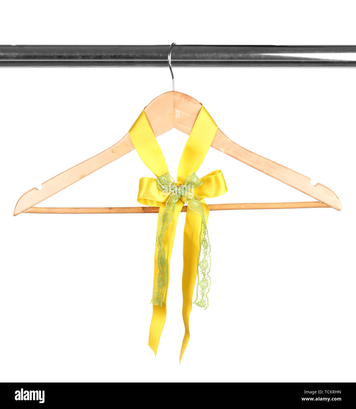 Beautiful yellow bow hanging on wooden hanger isolated on white Stock Photo