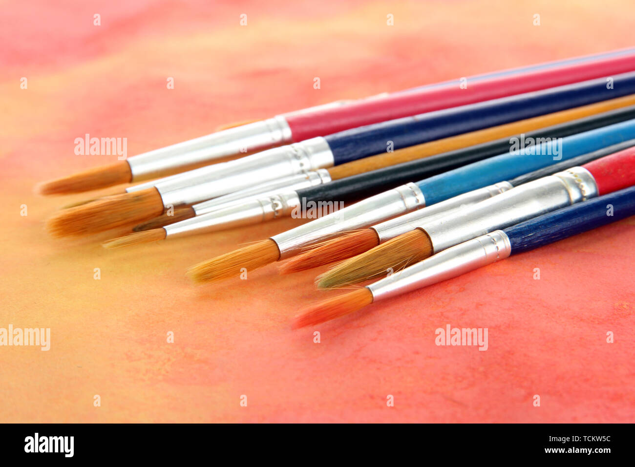 brushes on bright abstract gouache painted background Stock Photo