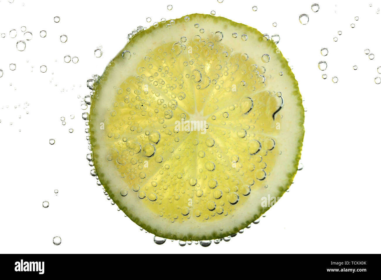slice of lime in the water with bubbles, isolated on white Stock Photo