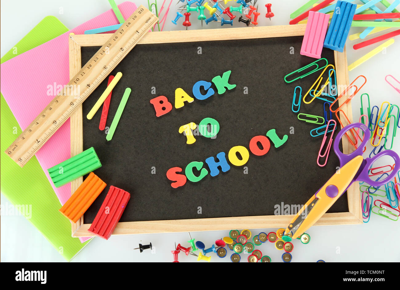 Small chalkboard with school supplies on white background. Back to ...