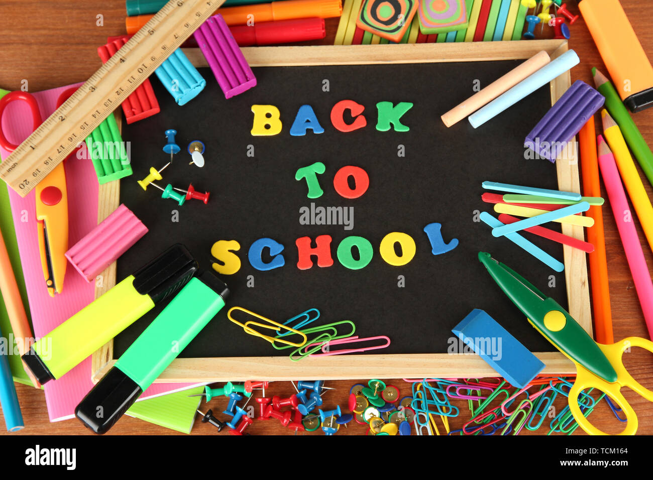 Small chalkboard with school supplies on wooden background. Back to ...