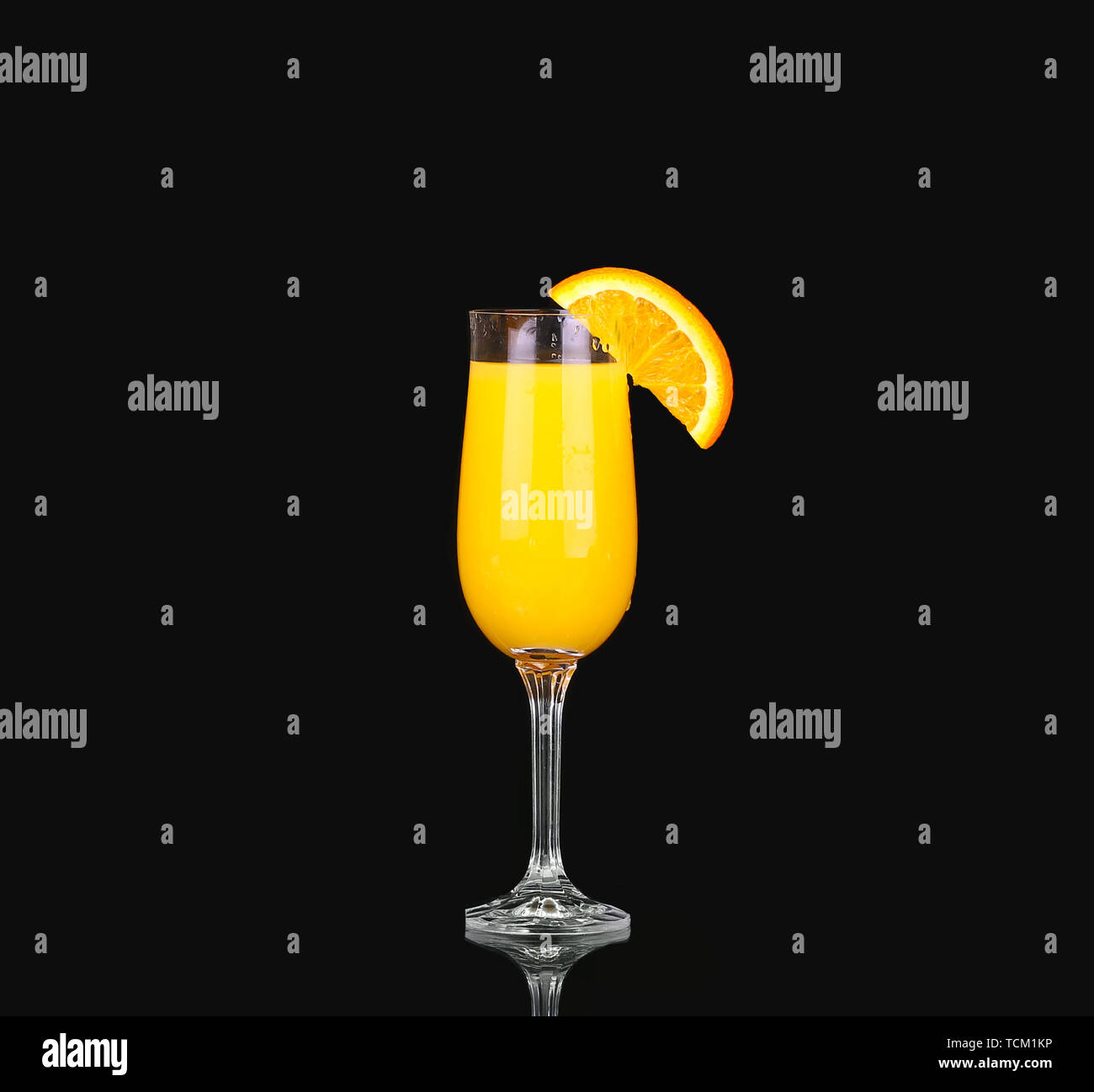 fresh organic orange juice and vodka in a tall glass on a black