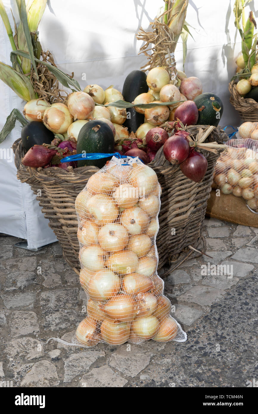 Different types of onions in bags and basket at local onion festival