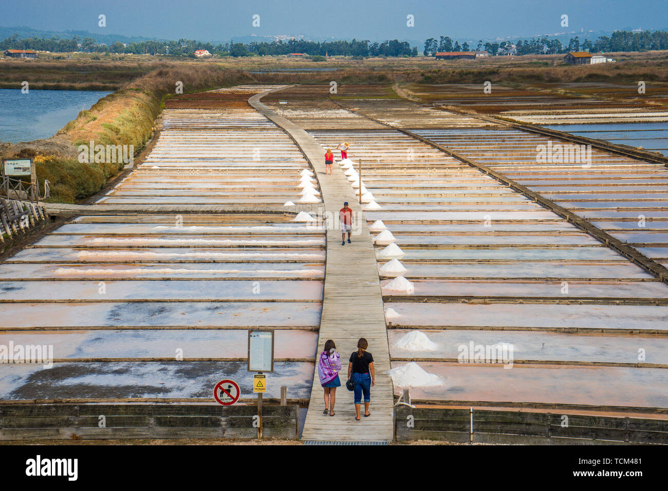 People walking between the salt beds where salt production through solar evaporation of sea water Figuera da Foz Portugal Stock Photo