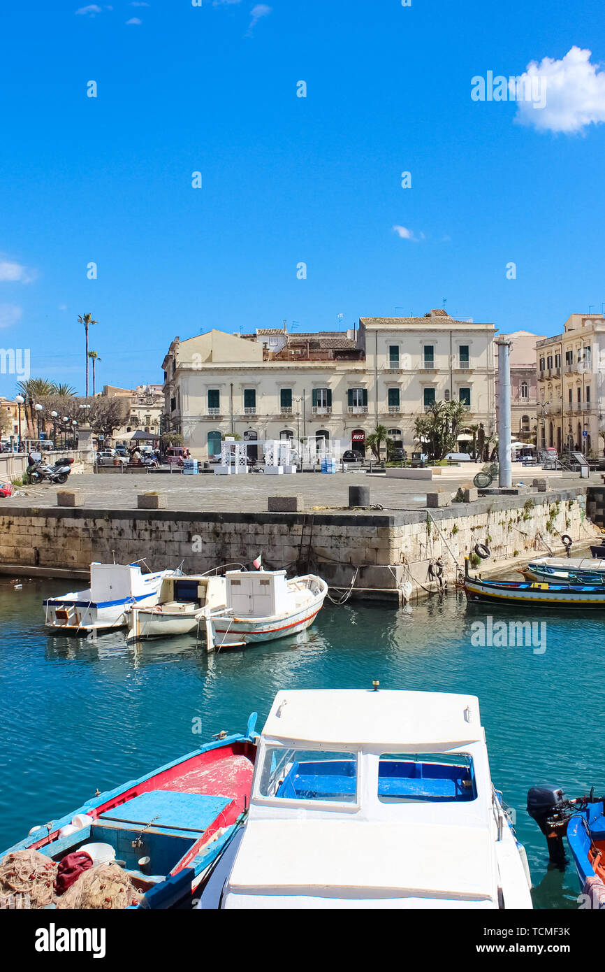 Syracuse, Sicily, Italy - Apr 10th 2019: Beautiful harbour between the city of Syracuse and famous Ortigia Island taken on a sunny day. Part of UNESCO World Heritage. Popular tourist destination. Stock Photo