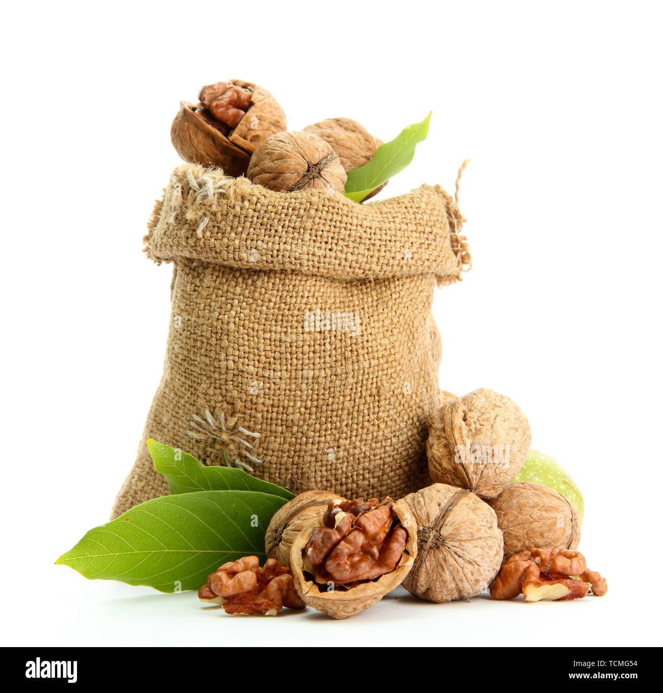 walnuts with green leaves in burlap bag, isolated on white Stock Photo