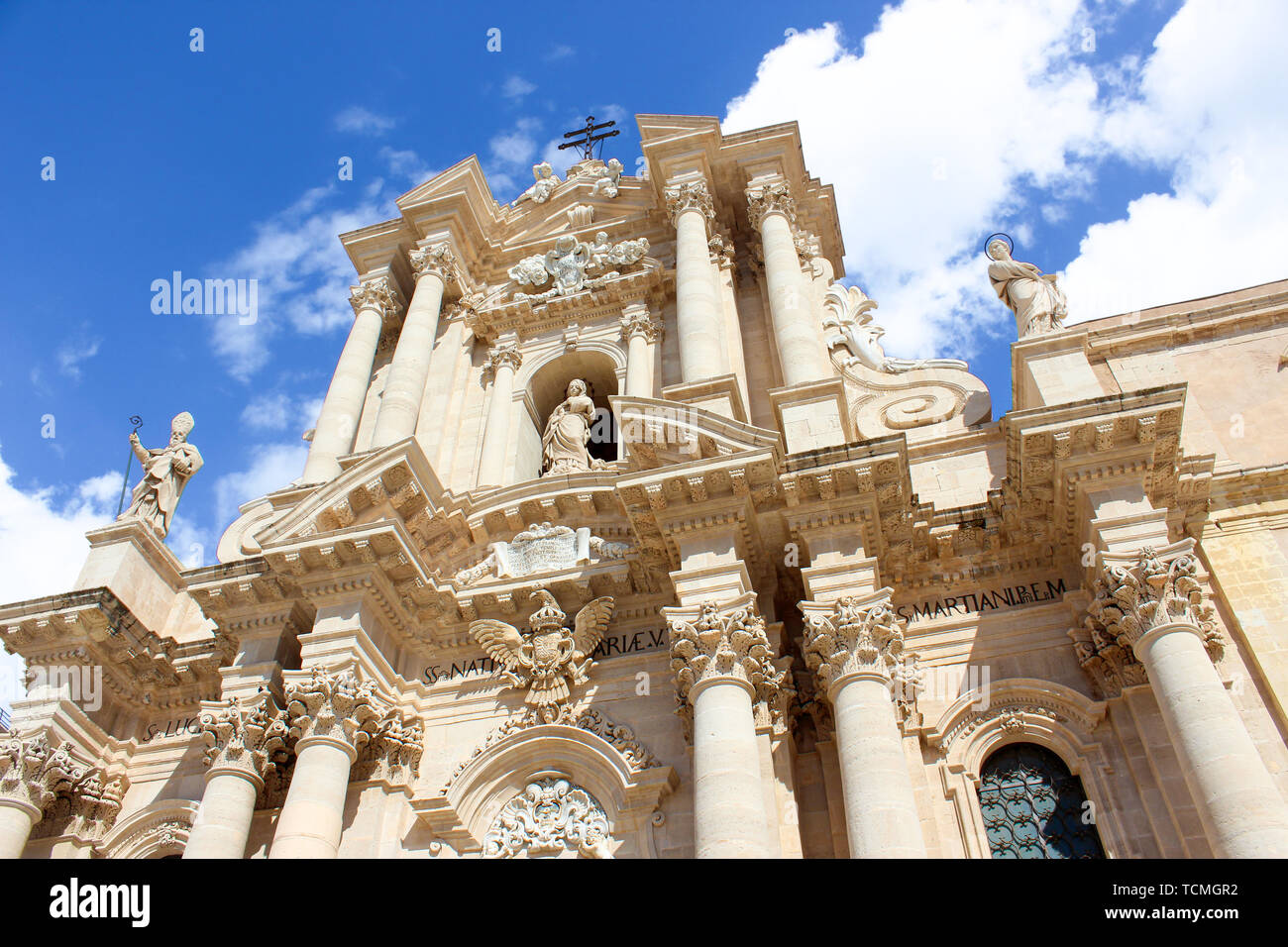 Amazing Roman Catholic Cathedral of Syracuse in Sicily, Italy photographed from below against blue sky. The church is part of UNESCO World Heritage. Popular tourist attraction. Stock Photo