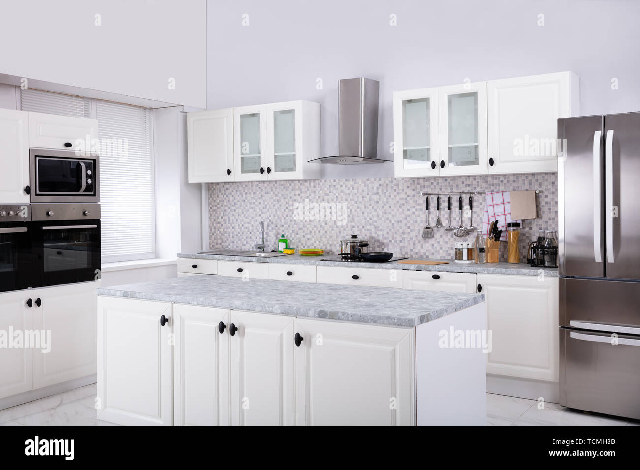 Interior Of Modern White Clean Kitchen With Microwave Oven And Refrigerator Stock Photo