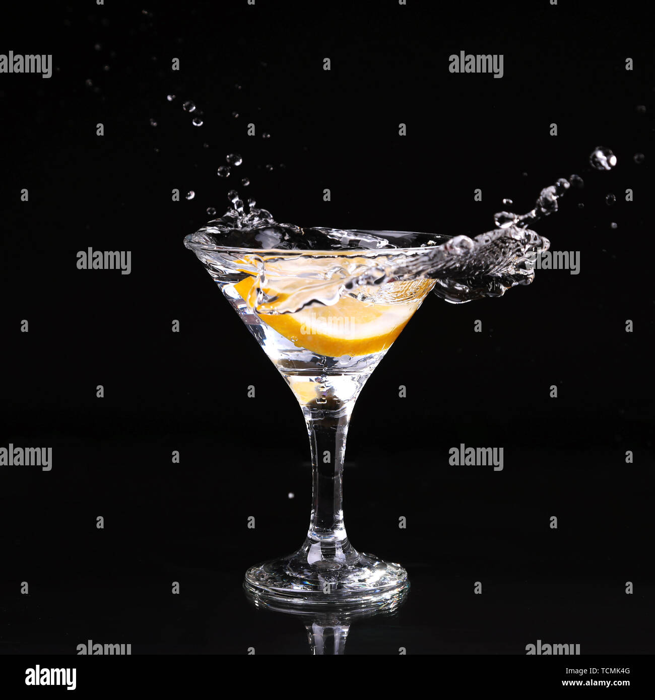martini cocktail splashing into glass on black background Stock Photo