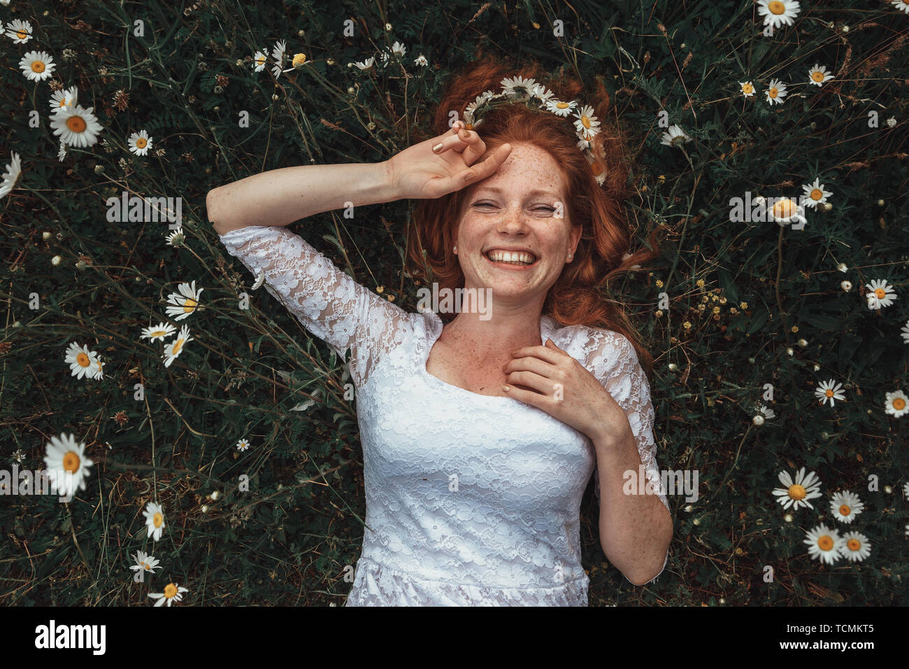Beautiful young girl with curly red hair in chamomile field Stock Photo ...