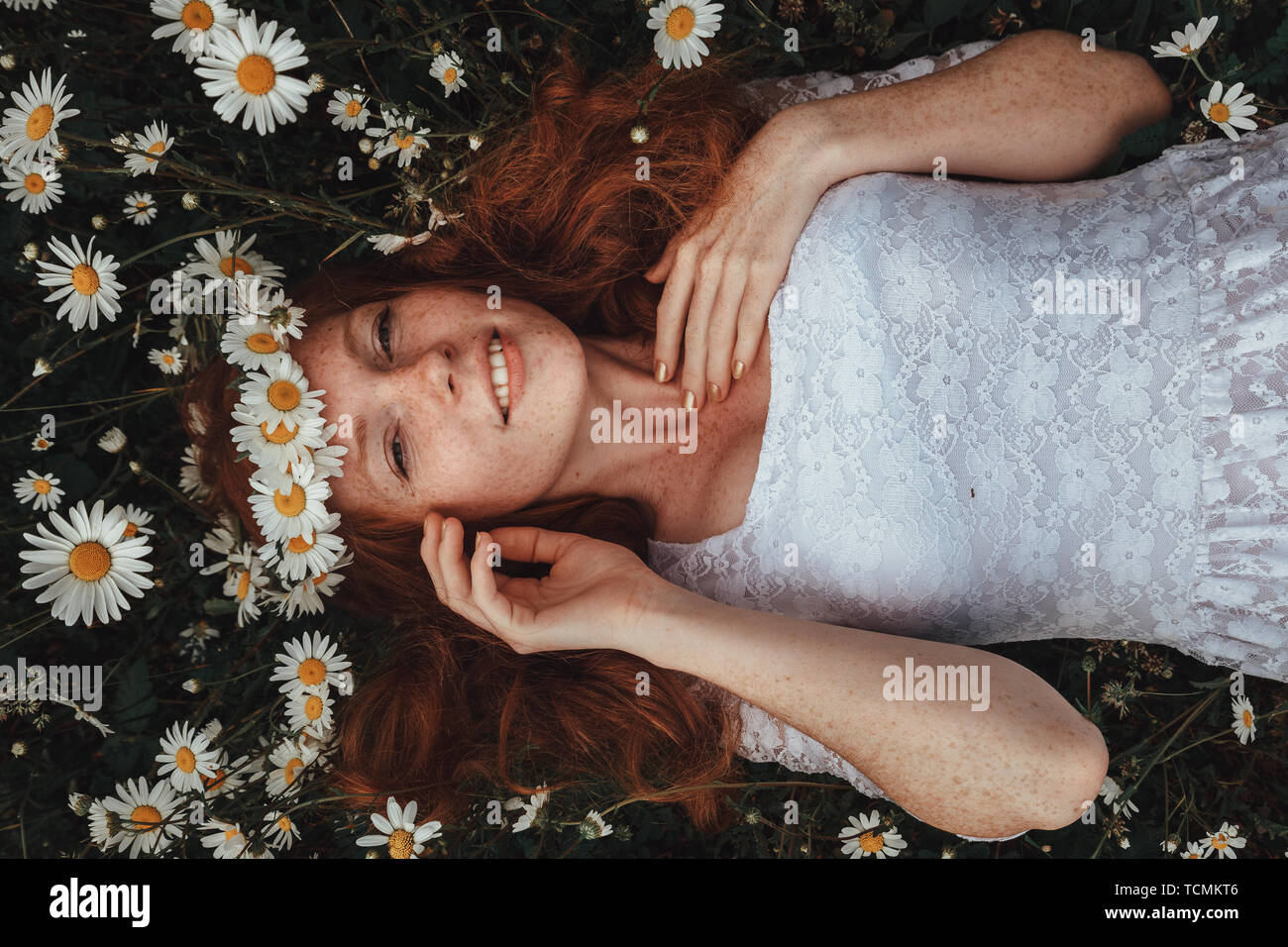 Beautiful young girl with curly red hair in chamomile field Stock Photo ...