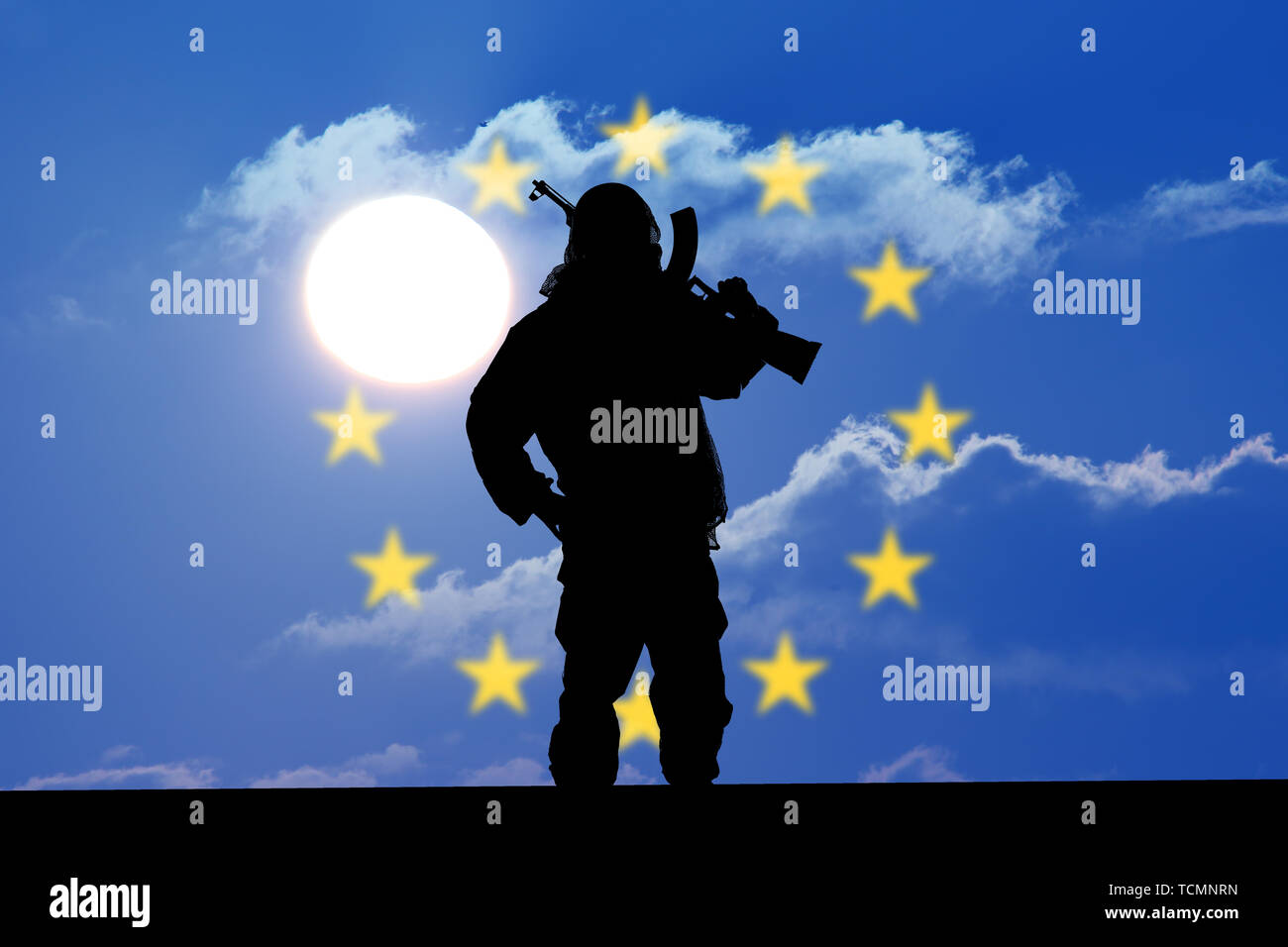 Silhouette of soldier with weapons at sunset. holding gun. Concept of a terrorist. Silhouette terrorists, national flag on background - European Union Stock Photo
