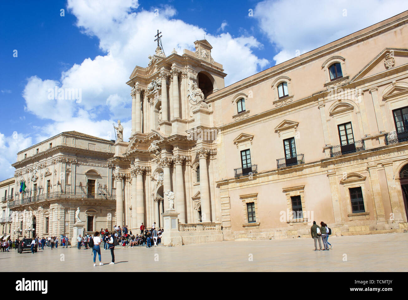 Syracuse, Italy - Apr 10th 2019: Beautiful Roman Catholic Cathedral of Syracuse in Sicily with tourists on the adjacent square. The church is part of UNESCO World Heritage. Popular tourist attraction. Stock Photo