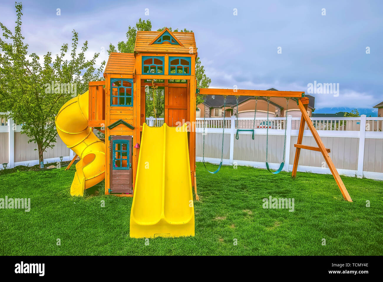 Playground On A Backyard With View Of Homes And Cloudy Sky Beyond