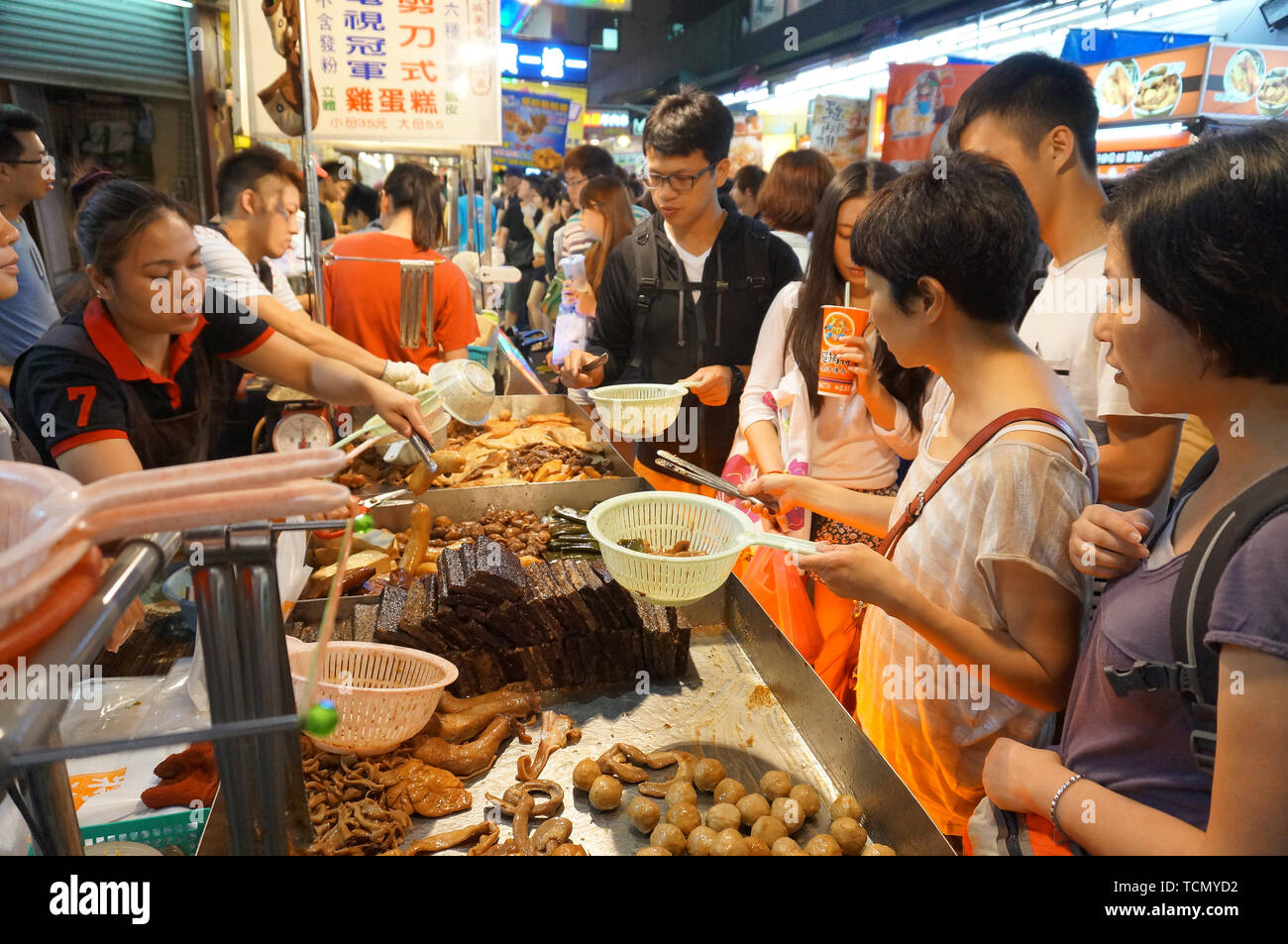 TAIPEI, TAIWAN - JULY 13, 2013: Customers ordering Chinese street food consisting of braised beef and pork entrails in Taipei's Shilin Night Market, t Stock Photo