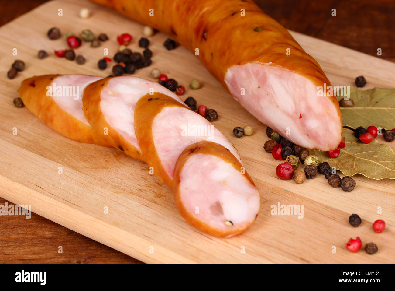 Tasty sausage on chopping board on browm background Stock Photo - Alamy