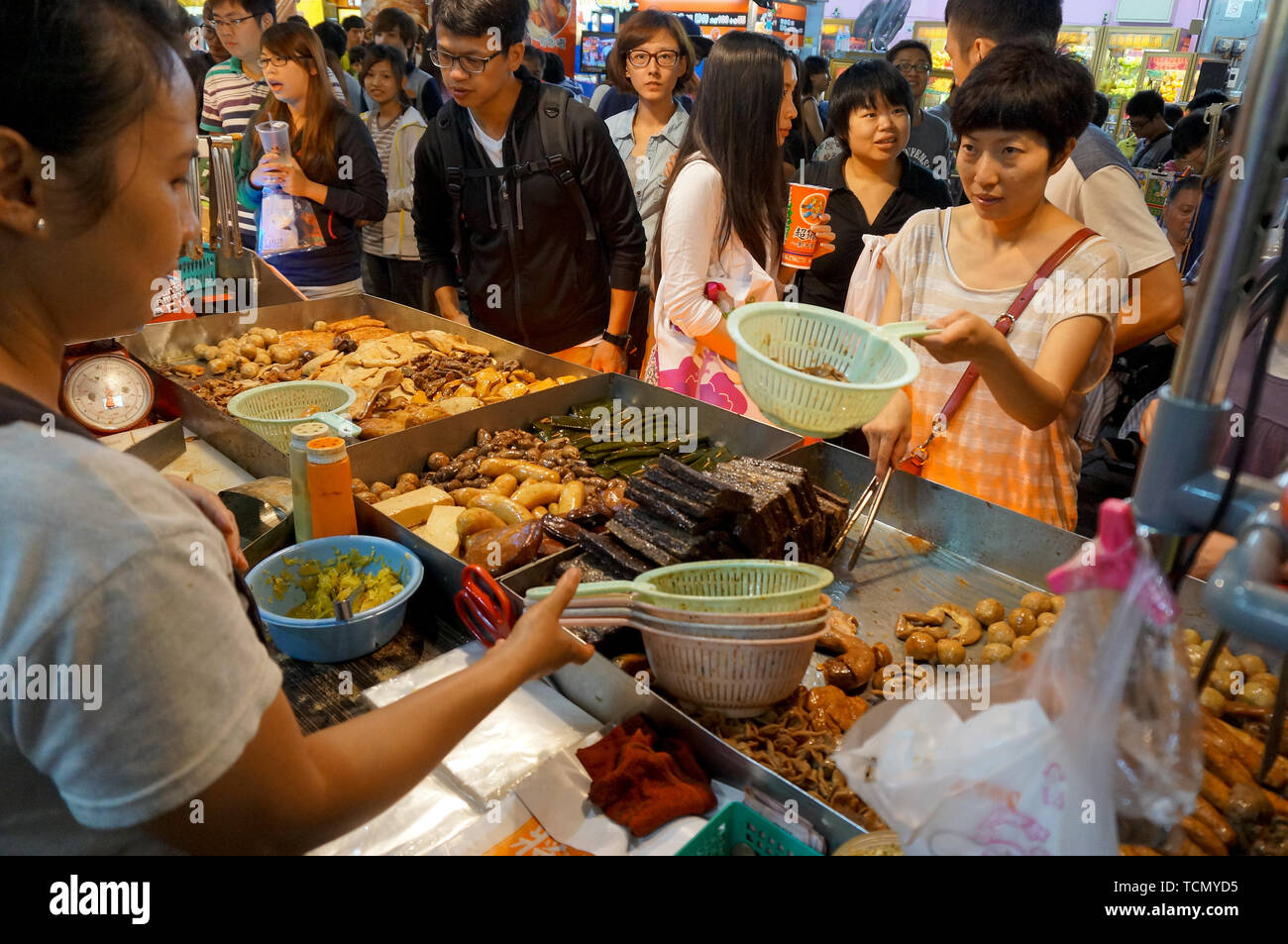 TAIPEI, TAIWAN - JULY 13, 2013: Customers ordering Chinese street food consisting of braised beef and pork entrails in Taipei's Shilin Night Market, t Stock Photo