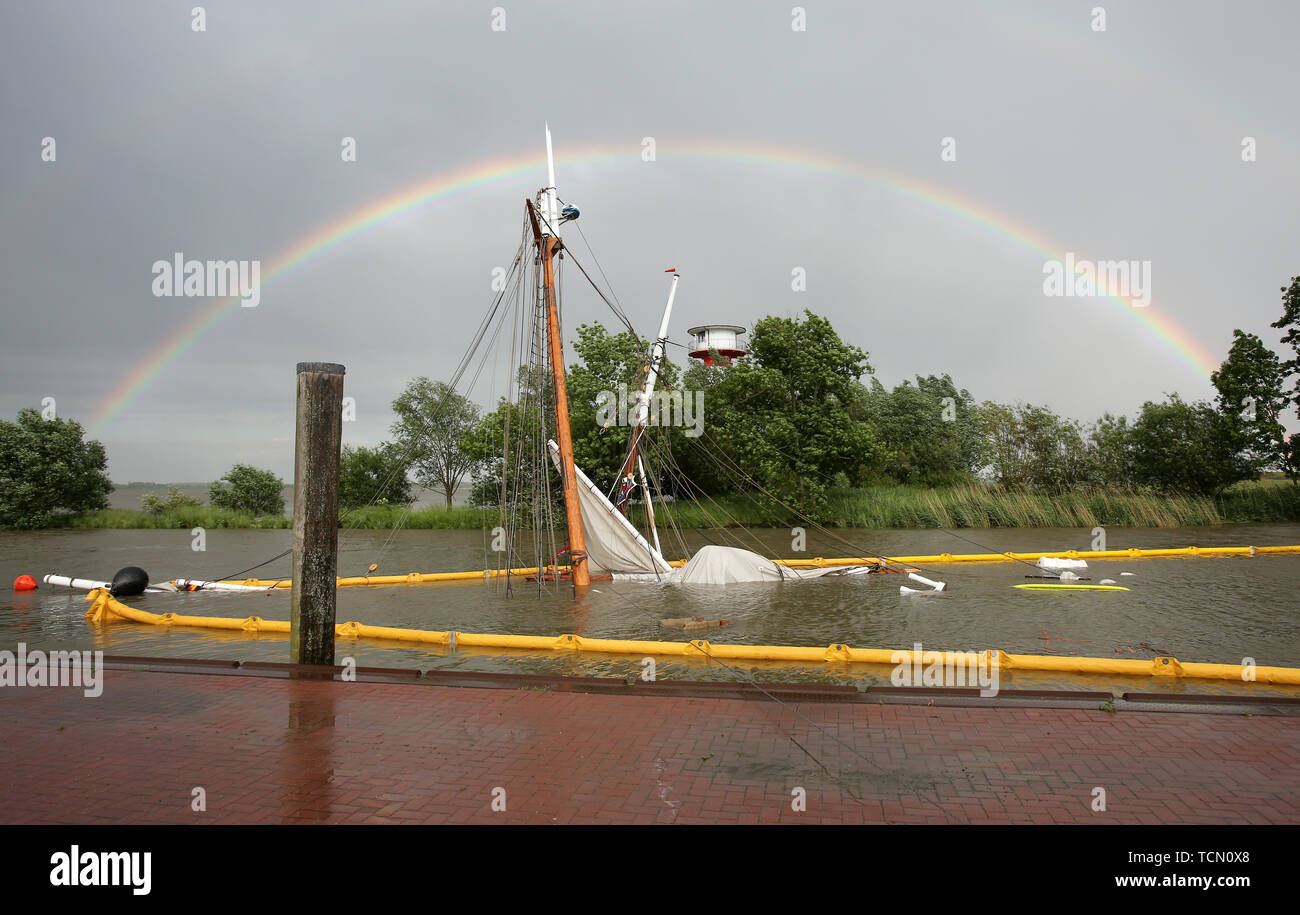 Stadersand, Germany. 08th June, 2019. The sunken historic sailing ship 'No 5 Elbe' is almost completely under water in the harbour of Stadersand. In the background you can see a rainbow. The historical sailing ship, which has only recently been extensively renovated, collided with a container ship on the Elbe and sank. Five people were injured in the accident in Stade on Saturday, one of them a woman, according to the Hamburg police. Credit: Bodo Marks/dpa/Alamy Live News Stock Photo