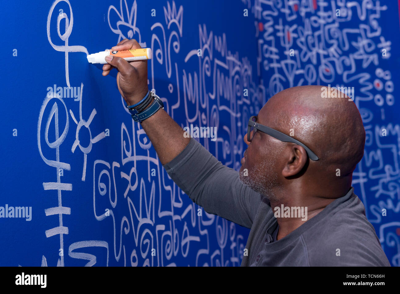 London, UK. 9 June 2019.  Nigerian-American artist, Victor Ekpuk, makes the final touches to his large-scale Afrofuturisrtic mural, 'Shrine to Wisdom, ahead of the opening of a major new exhibition 'Get up, Stand Up Now' at Somerset House which runs 12 June to 15 September 2019.  The exhibition celebrates over 50 years of Black creativity in Britain and beyond, showcasing works by over 100 artists. Credit: Stephen Chung / Alamy Live News Stock Photo