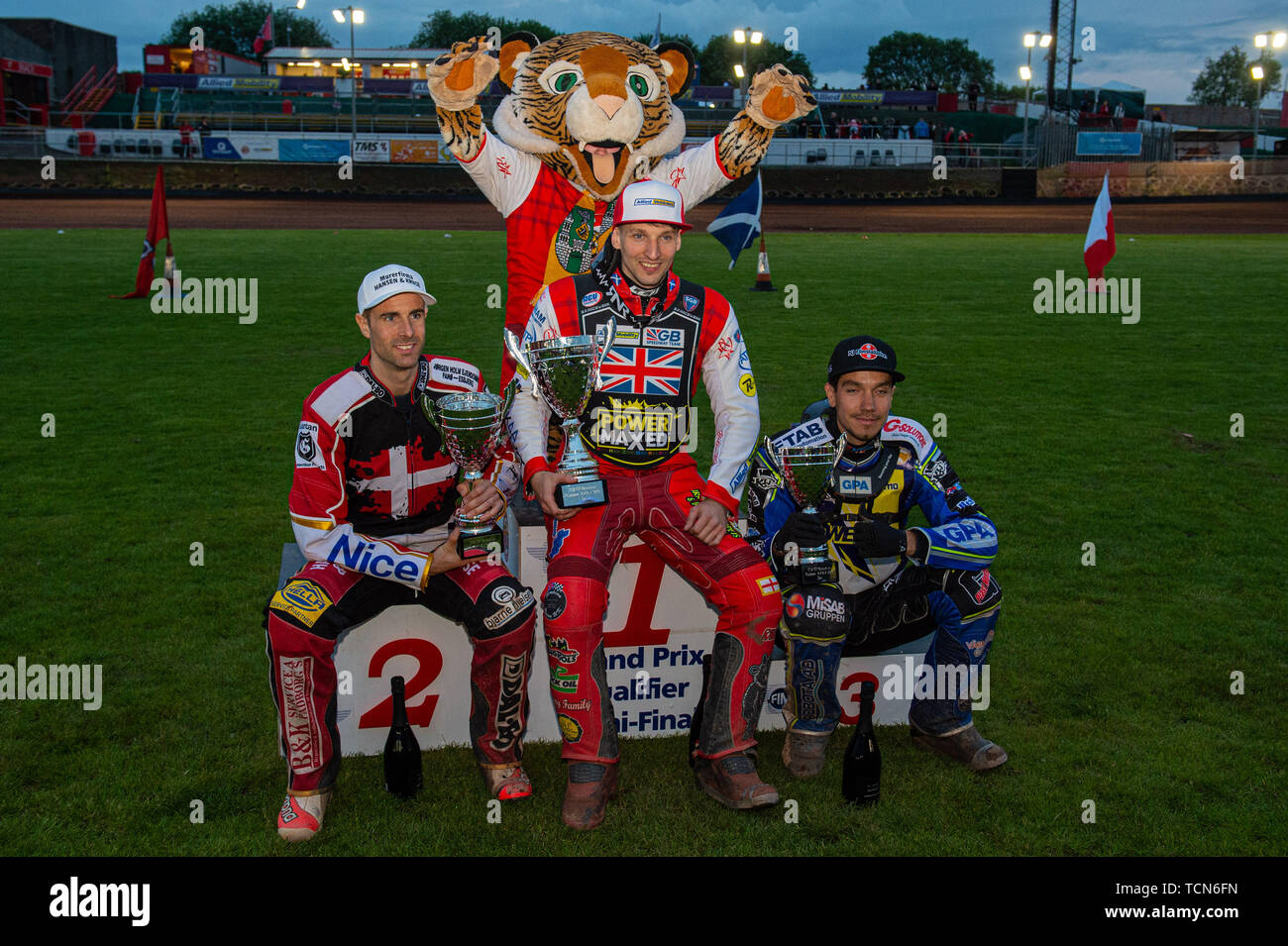 Glasgow, Scotland, UK. 08th June, 2019.  Top 3: Niels-Kristian Iversen (2nd), Craig Cook (1st), Pontus Aspgren (3rd) with Glasgow Mascot Roary (Rear) during the FIM Speedway Grand Prix World Championship - Qualifying Round 1 at the Peugeot Ashfield Stadium, Glasgow on Saturday 8th June 2019. (Credit: Ian Charles | MI News) Credit: MI News & Sport /Alamy Live News Stock Photo