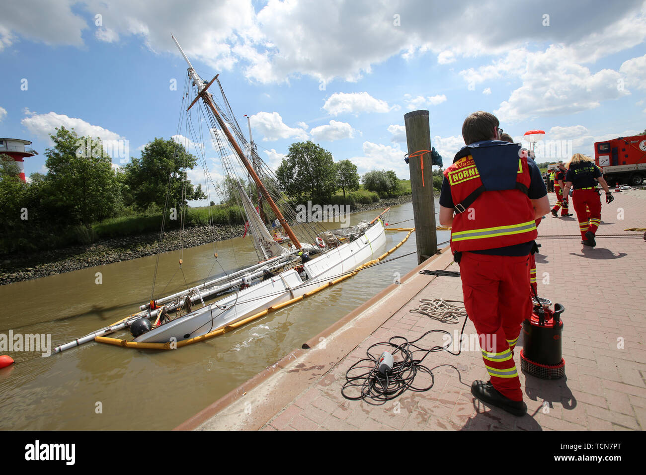 Stadersand, Germany. 09th June, 2019. DLRG employees are working on the sunken historic sailing ship 'No. 5 Elbe' in the port of Stadersand. The historical sailing ship, a pilot schooner built in 1883, which was only recently extensively renovated, collided with a container ship on the Elbe and sank. Five people were injured in the accident in Stade on Saturday, one of them a woman, according to the Hamburg police. Credit: Bodo Marks/dpa/Alamy Live News Stock Photo
