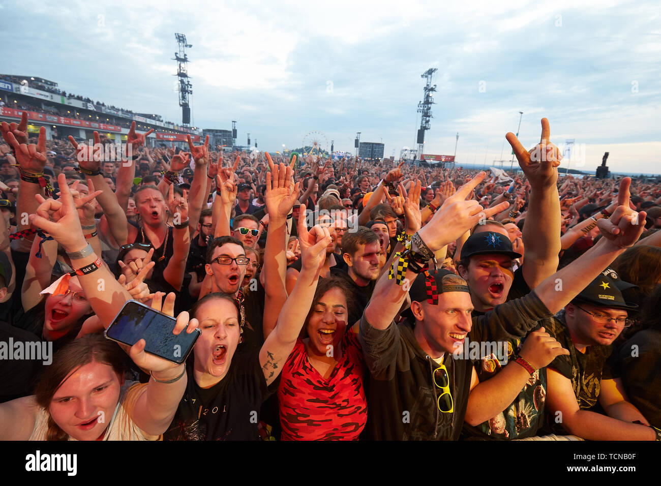 09 June 2019, Rhineland-Palatinate, Nürburg: Rock fans cheer in front of  the main stage of the open-air festival "Rock am Ring" during the  performance of the rock band "Tenacious D". On three