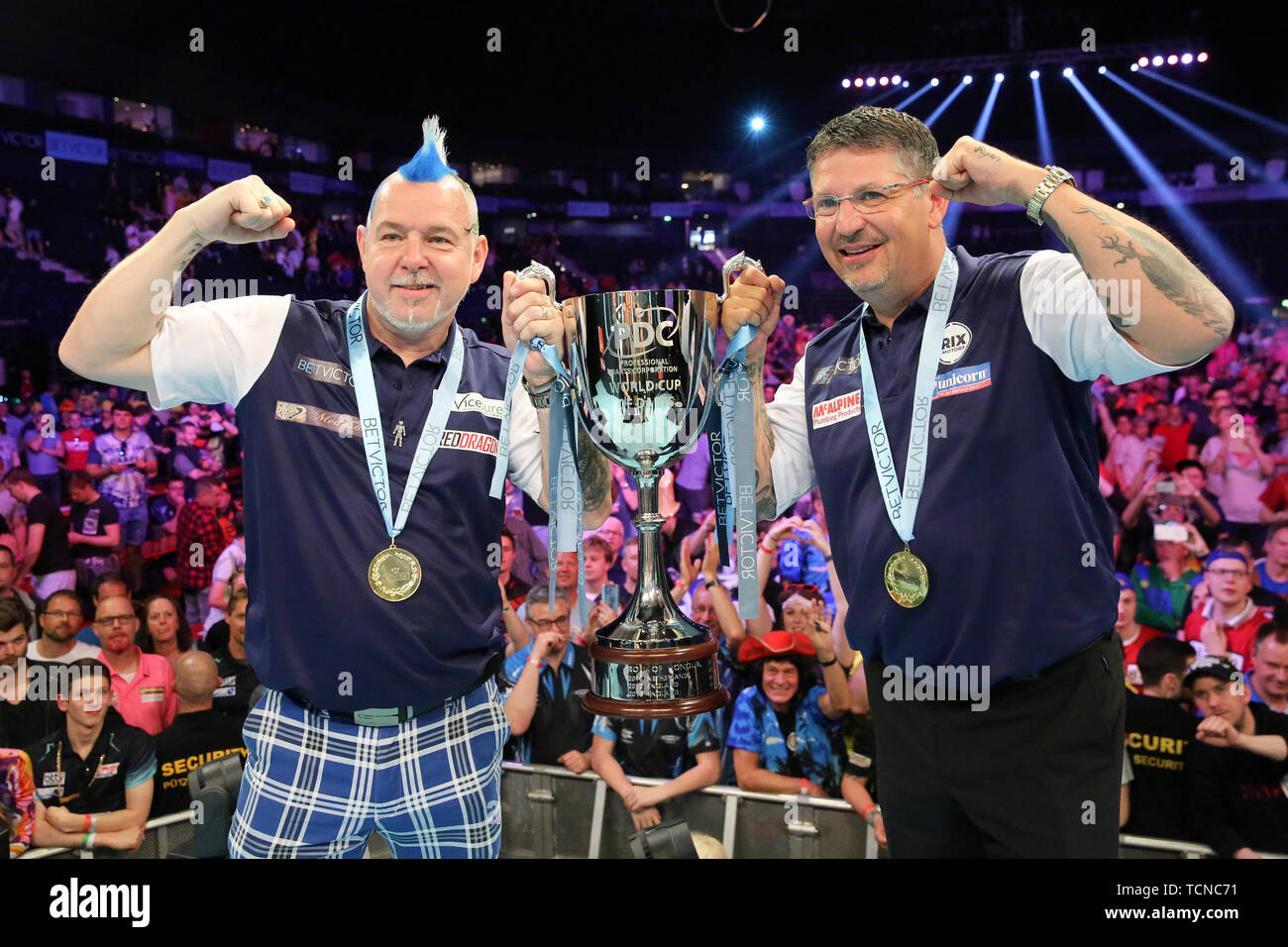 Hamburg, Germany. 09th June, 2019. Darts: Team World Championship, Final:  Scotland - Ireland. The winning team Peter Wright (l) and Gary Anderson  from Scotland pose with their trophy after the victory. Credit: