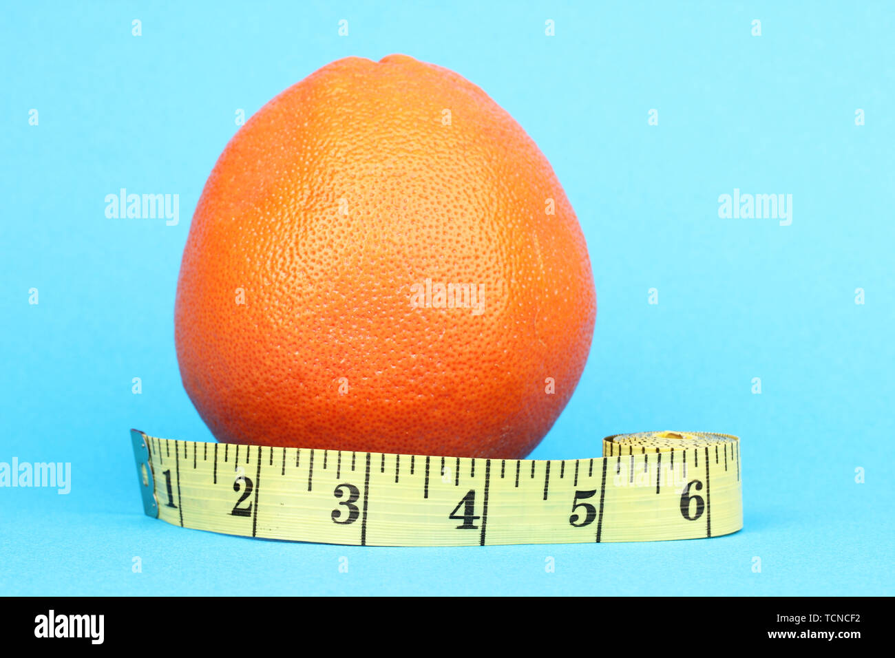 https://c8.alamy.com/comp/TCNCF2/orange-with-measuring-tape-on-blue-background-TCNCF2.jpg