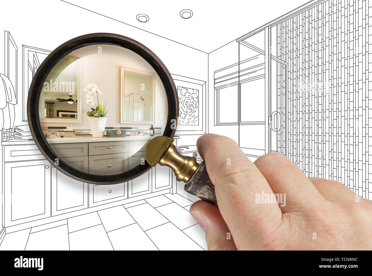 Hand Holding Magnifying Glass Revealing Custom Bathroom Design Drawing and Photo Combination. Stock Photo
