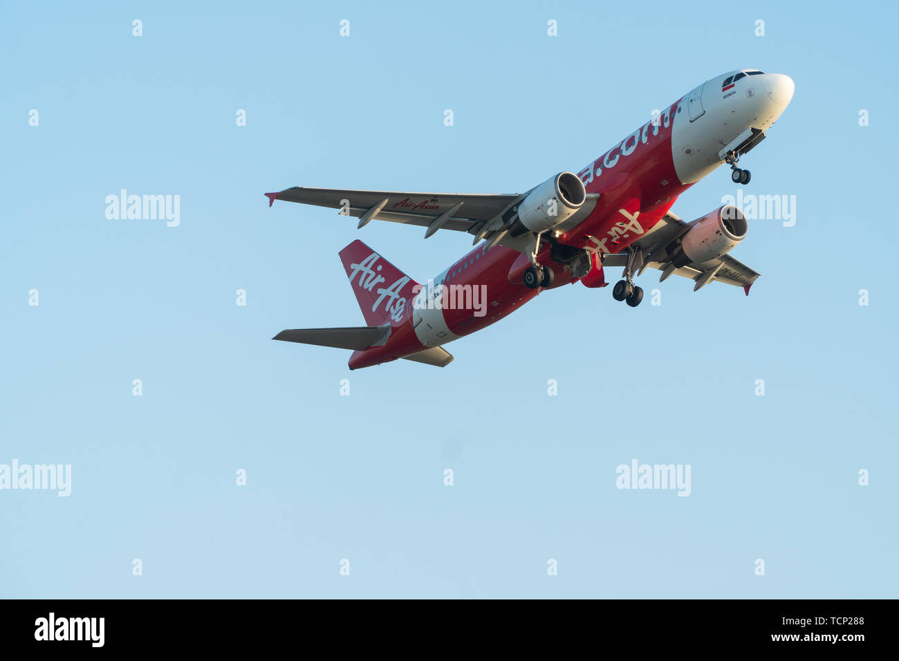BALI/INDONESIA-JUNE 06 2019: Air Asia, one of the airlines in Indonesia, is  flying over the blue sky. Landing gear is in the process of being stored  Stock Photo - Alamy