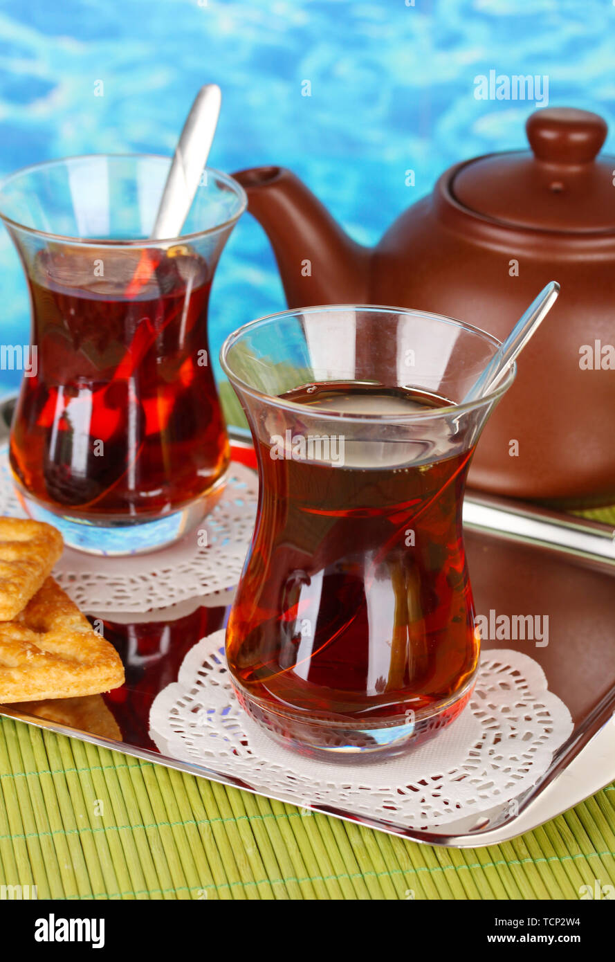 glass of Turkish tea and kettle on color background Stock Photo - Alamy