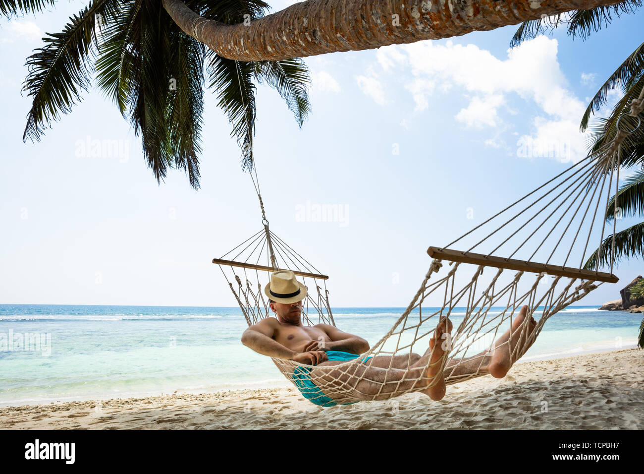 Closeup Of A Young Man Sleeping On Hammock In Front Of Idyllic Sea At