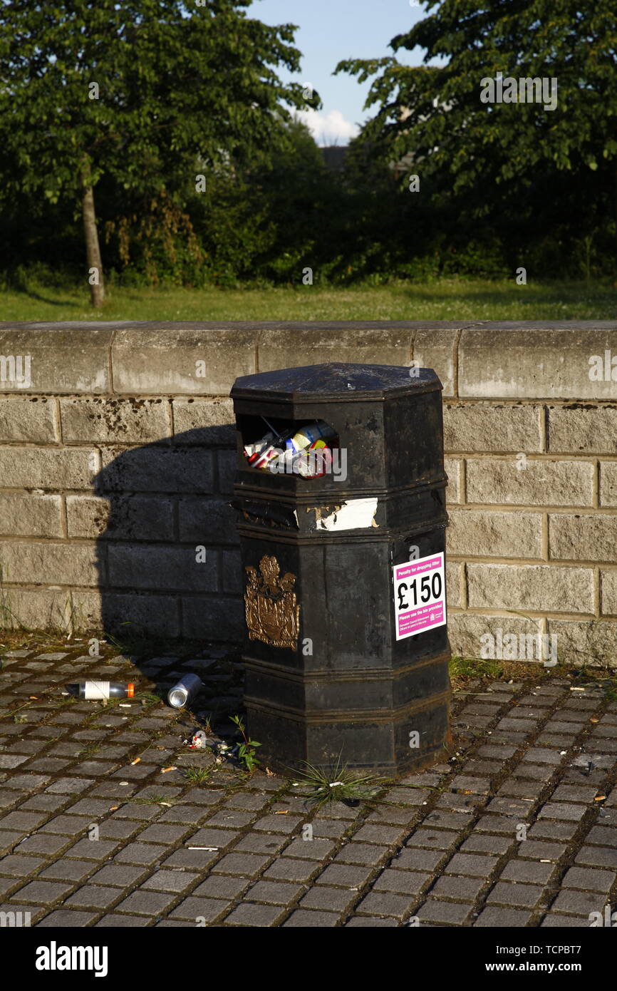 Overflowing rubbish bin in Doncaster town centre, in low evening light. Stock Photo