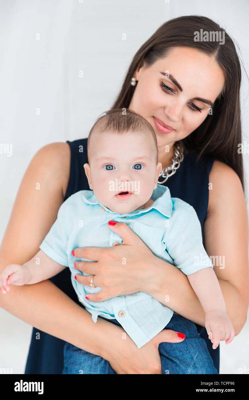 Photo of beautiful mother holds in her arms a little son Stock Photo
