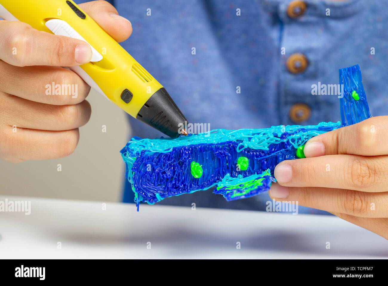 Boy hands creating with 3d pen blue plane Stock Photo - Alamy