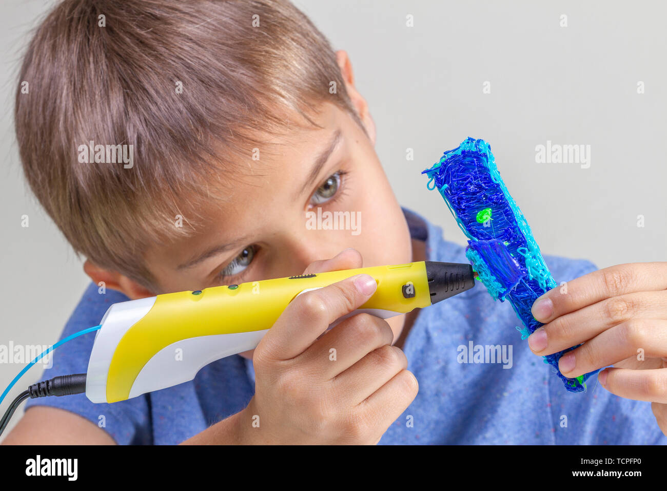 Boy hands creating with 3d pen blue plane Stock Photo - Alamy