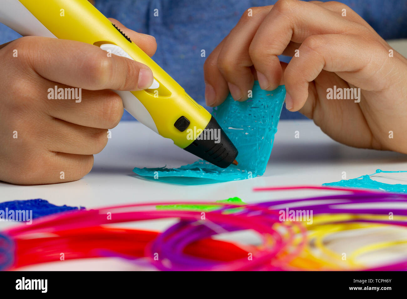 Kid hands with 3d printing pen creating new item Stock Photo - Alamy
