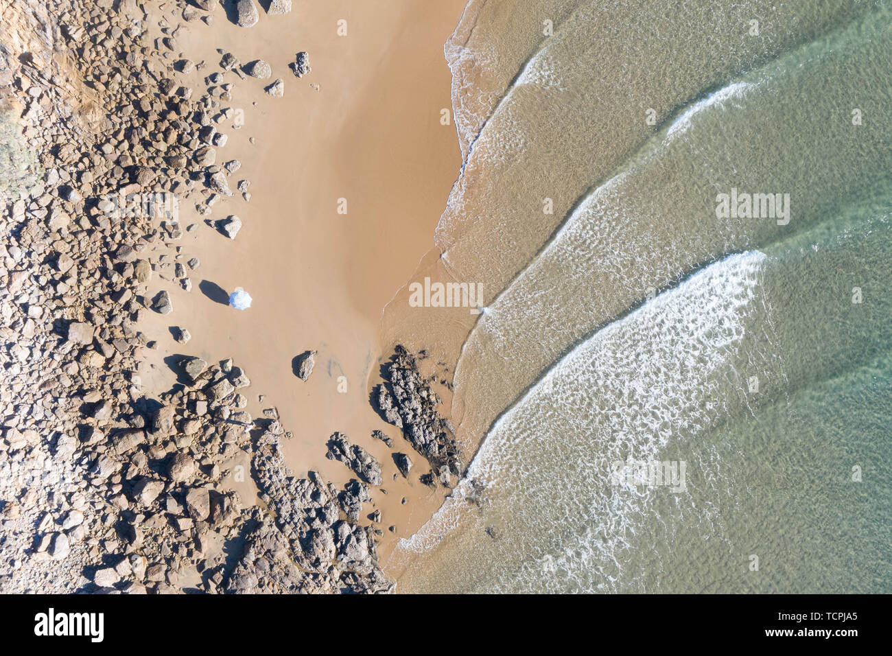 Top beautiful view of a beach at sunrise with beautiful waves lines, shallow turquoise water in a tropical holiday destination Stock Photo