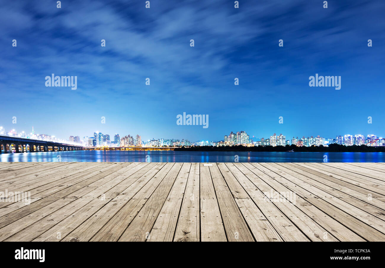 cityscape and skyline of seoul at night from empty wood floor Stock Photo