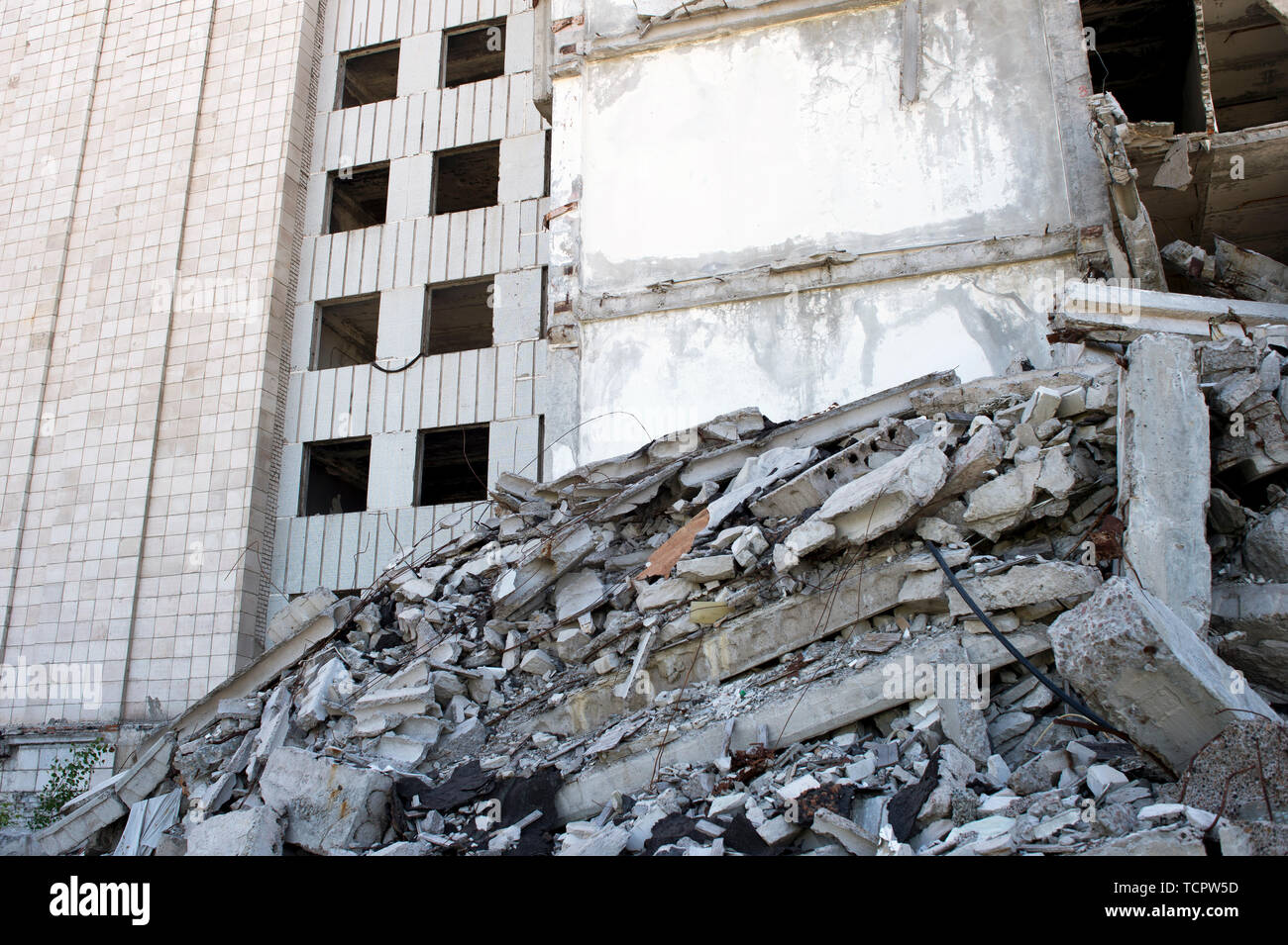 Destroyed large building with a blockage of concrete debris in the ...